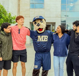 Monte hanging out with a group of students in front of the library