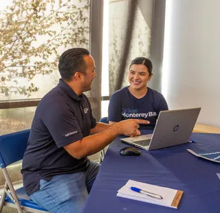 Two students sitting at a table with a laptop