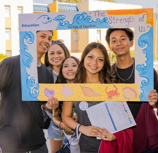 Students pose in photo frame at Open House
