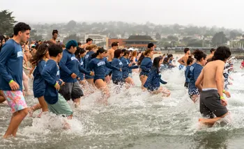 Students splash into the ocean at the Otter Plunge