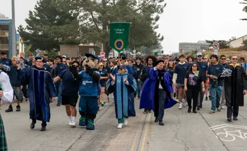President Vanya Quiñones and mascot Monte Rey lead the Convocation parade