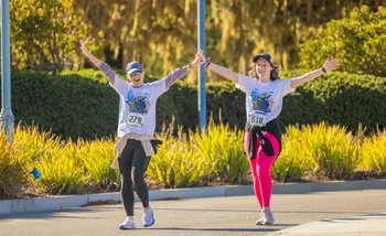 Two runners with hand up excitedly