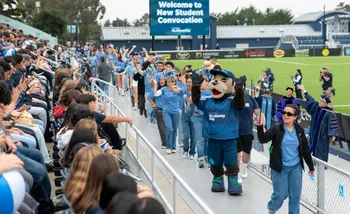 Monte Rey leads CSUMB staff in cheering on the students at the Stadium