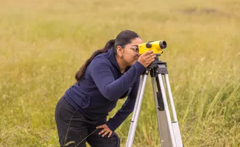 A girl is looking through a Spectra Precision instrument.