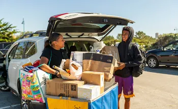 Male student on Move In day with supporter unloading boxes