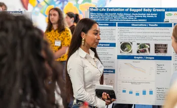 A student presenter stands in front of their graphic