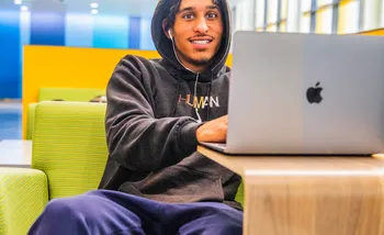 Student on a laptop in a seating area