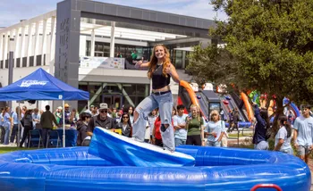 Student on a foam surf board at Convocation