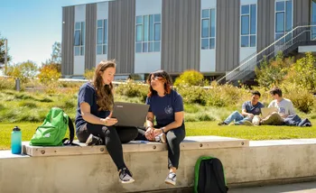 Students studying outdoors with a laptop