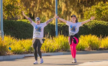 Two runners with hand up excitedly