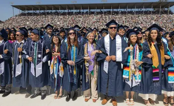 Students at Commencement in regalia, Salinas Sports Center