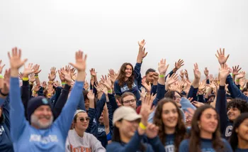 Group of students with hands raised before Annual Plunge