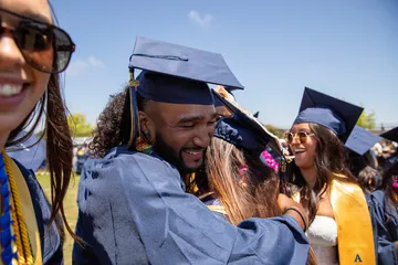 Two students embracing at graduation