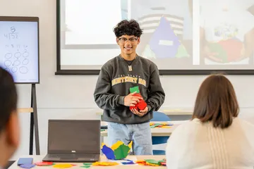 A student presenting in front of the classroom