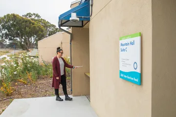 A staff member checks in at a campus office location, highlighting accessible services and support for the university community.