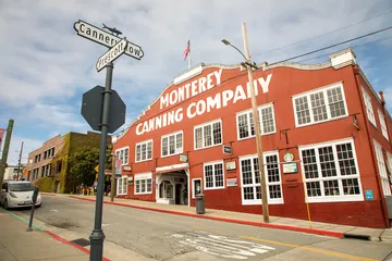 The historic Monterey Canning Company building stands along a coastal street, reflecting the region’s rich cultural and economic history.