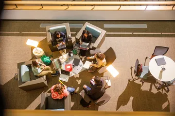 Students sitting in the library collaborating