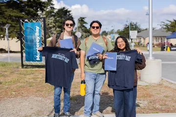 Students holding CSUMB t shirts