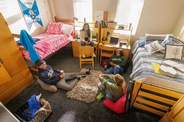 Students sitting around a dorm room talking