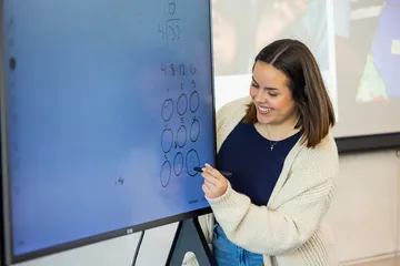 A faculty member writing on the board