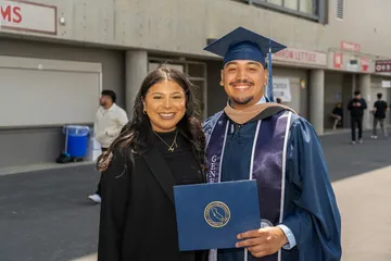 A graduate and a family member posing for a photo