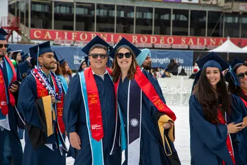 Two students posing in their cap and gown