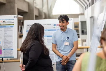 Student giving presentation with poster