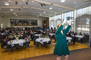 Woman is taking a photo of people gathered in a conference room