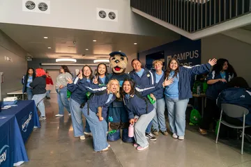 Orientation leaders taking a photo with mascot Monte