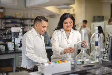 A student working with assistant professor JP Dundore-Arias in a lab setting