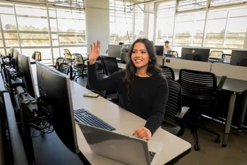A student sitting down raising their hand to ask a question