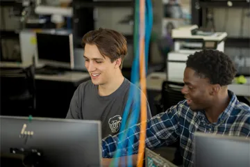 Two students collaborating together in the business and information technology building