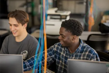 Two students collaborating together in the business and information technology building