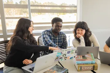 A group of students collaborating in a computer lab in the buissness and information technology building