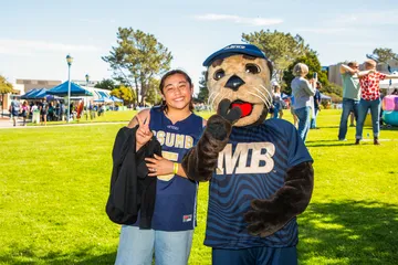An MB Madness participant wearing a CSUMB jersey poses with Monte