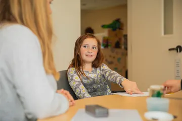 Child student sitting at table in reading center