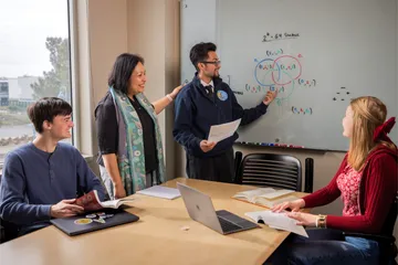 Three statistics students in a meeting with Dr. Deka