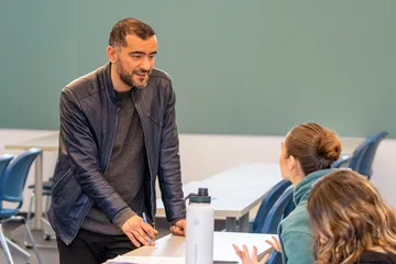 Teacher talking to students during a classroom discussion.