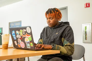 Student looking at a laptop on a desk