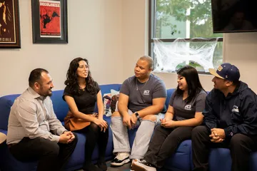 Group of people sitting on the sofa and having conversation