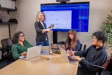 Four people are engaged in a conversation while sitting together in a room.