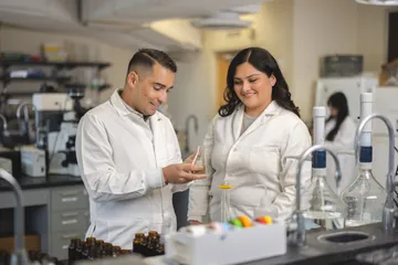 Professor showing student how to work with some materials in a lab.