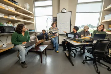 Students sitting together, smiling with each other in the break room.