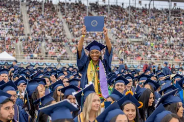 Student at Commencement holding diploma