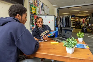 Faculty member pointing to paper with student at a table