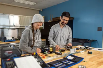 Two student working togther on a machine in the mechatronics lab