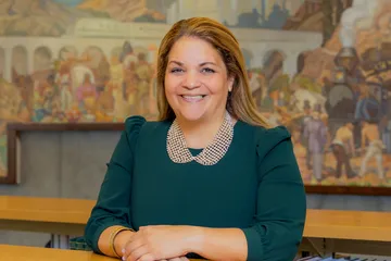 President Vanya Quiñones sits at her desk in her official portrait.