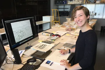 Girl sitting in front of computer and smiling