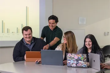 A group of four business administration students collaborating