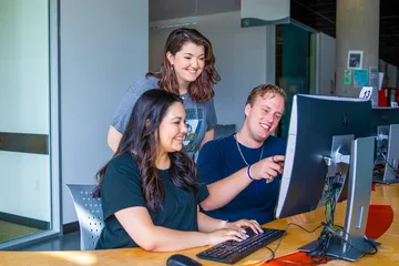 Three students using the computer at the library
